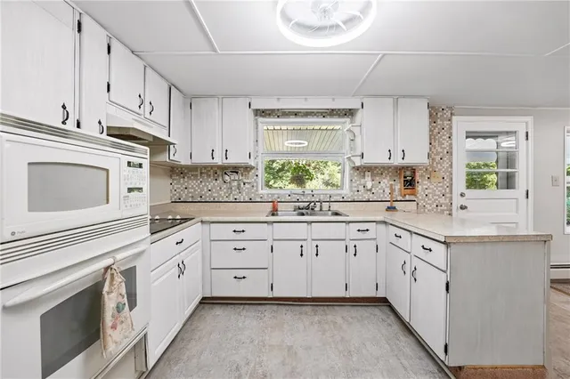 a kitchen with granite countertop white cabinets and white appliances