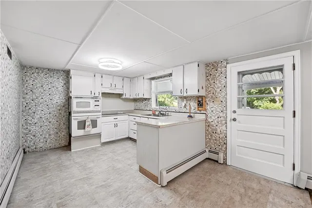 a kitchen with white cabinets and white appliances
