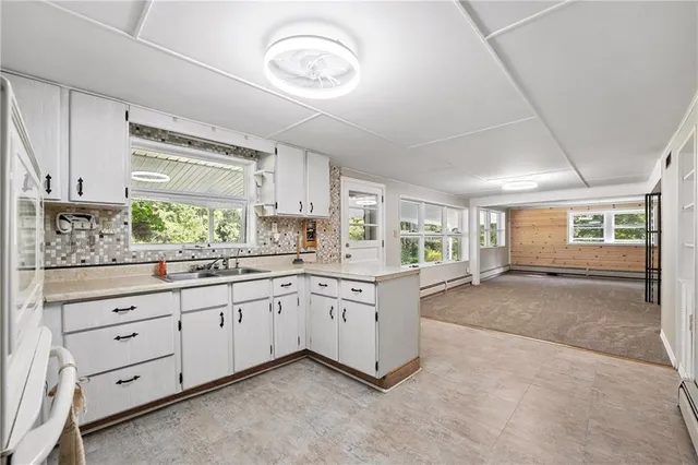 a kitchen with granite countertop white cabinets and white appliances