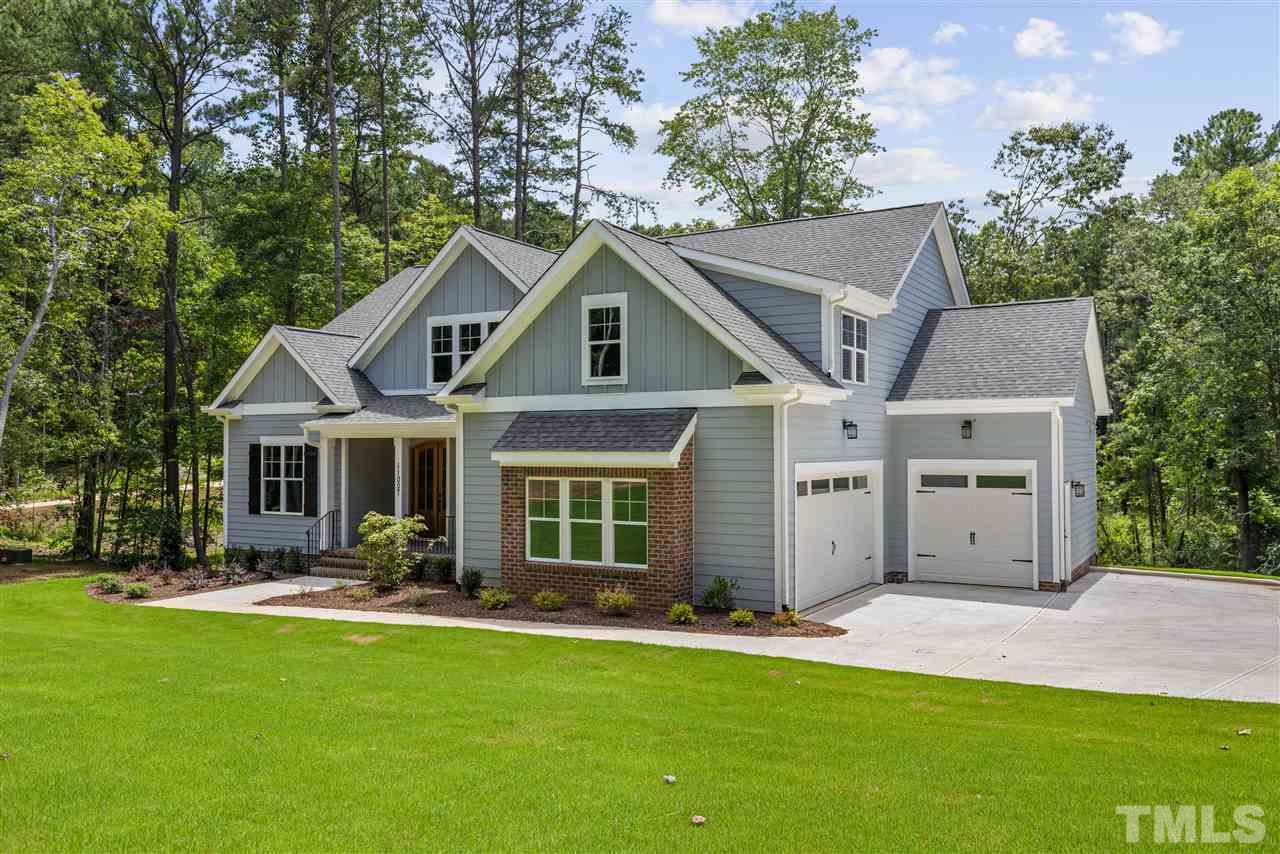 11007 Crest Mist Circle Raleigh, NC 27613 - Photo 2 of 30 The home has a 3 car garage (double side plus single front), plus a side parking pad and a long driveway. The exterior is low maintenance fiber cement, board and batten with brick accents.