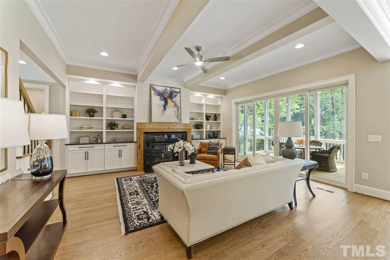 11007 Crest Mist Circle Raleigh, NC 27613 - Photo 10 of 30 Built ins frame the wood surround gas fireplace. Shiplap highlights the wall behind the built ins. There is recessed lighting, beams and sliders that open to the screened porch. Designer inspired ceiling fans and light fixtures throughout.