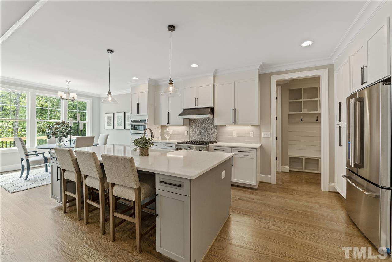 11007 Crest Mist Circle Raleigh, NC 27613 - Photo 11 of 30 A chef's dream with GE Cafe appliances including a 6 burner gas range, dishwasher, microwave, GE Monogram fridge and a custom crafted range hood. There is a large subway tile backsplash w/ accents behind the stove. Undercabinet lighting for ambience.