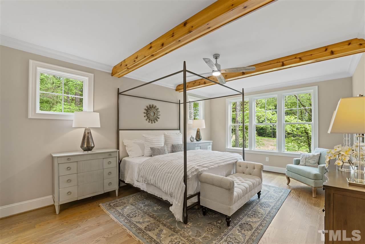 11007 Crest Mist Circle Raleigh, NC 27613 - Photo 5 of 30 The first floor master bedroom suite is nestled off the family room behind the fireplace wall. Beams accent this room as well. The hardwoods flow throughout the main floor (except baths and laundry).