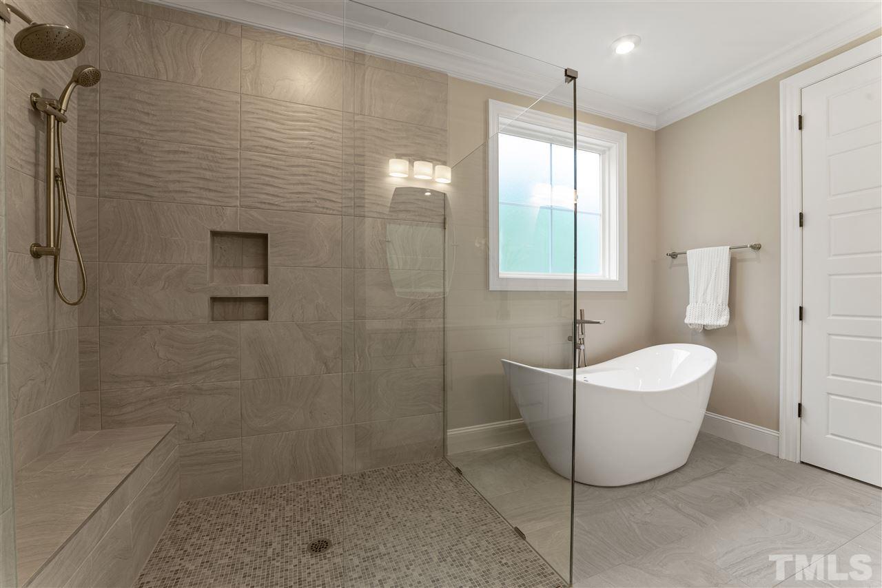 11007 Crest Mist Circle Raleigh, NC 27613 - Photo 7 of 30 The master bathroom boasts a huge walk in shower with rain head plus an arm showerhead for convenience, a bench in the shower and niche plus frameless glass. There is a free-standing tub too!