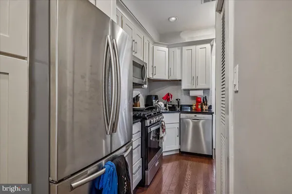 a kitchen with stainless steel appliances a refrigerator sink and cabinets