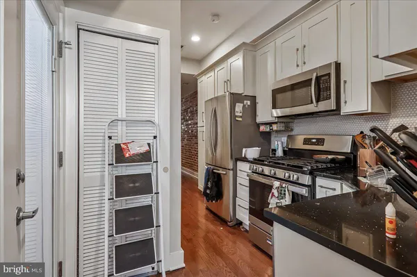 a kitchen with stainless steel appliances granite countertop a stove a refrigerator and a microwave