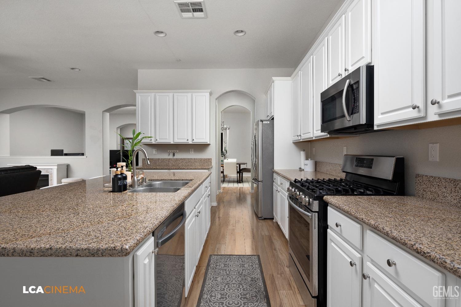 Undisclosed Address Bakersfield, CA 93314 - Photo 12 of 29 a kitchen with stainless steel appliances granite countertop a sink stove and microwave