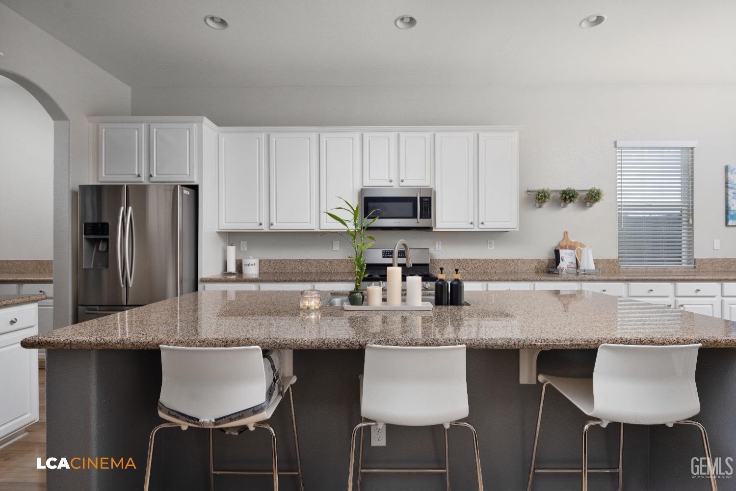 Undisclosed Address Bakersfield, CA 93314 - Photo 13 of 29 a kitchen with stainless steel appliances granite countertop a table chairs microwave and sink