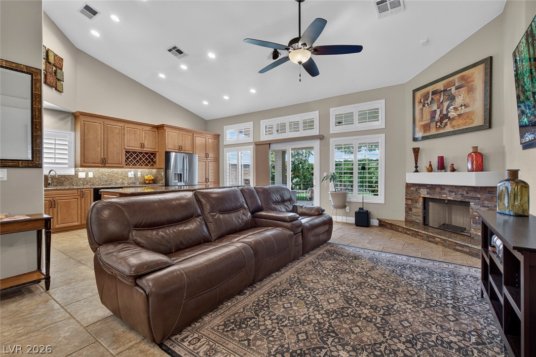 818 Manor Shores Road Henderson, NV 89002 - Photo 11 of 35 An open concept living area seamlessly blends a well-appointed kitchen with a spacious entertainment zone, centered by a stone-faced fireplace.