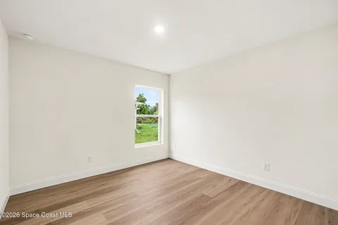 an empty room with wooden floor and a window
