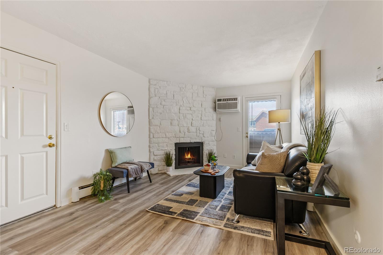 a living room with furniture a fireplace a rug and a window