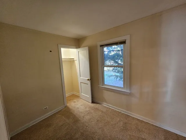 an empty room with windows and closet
