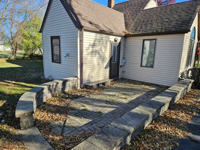 a view of a house with a yard and a large tree