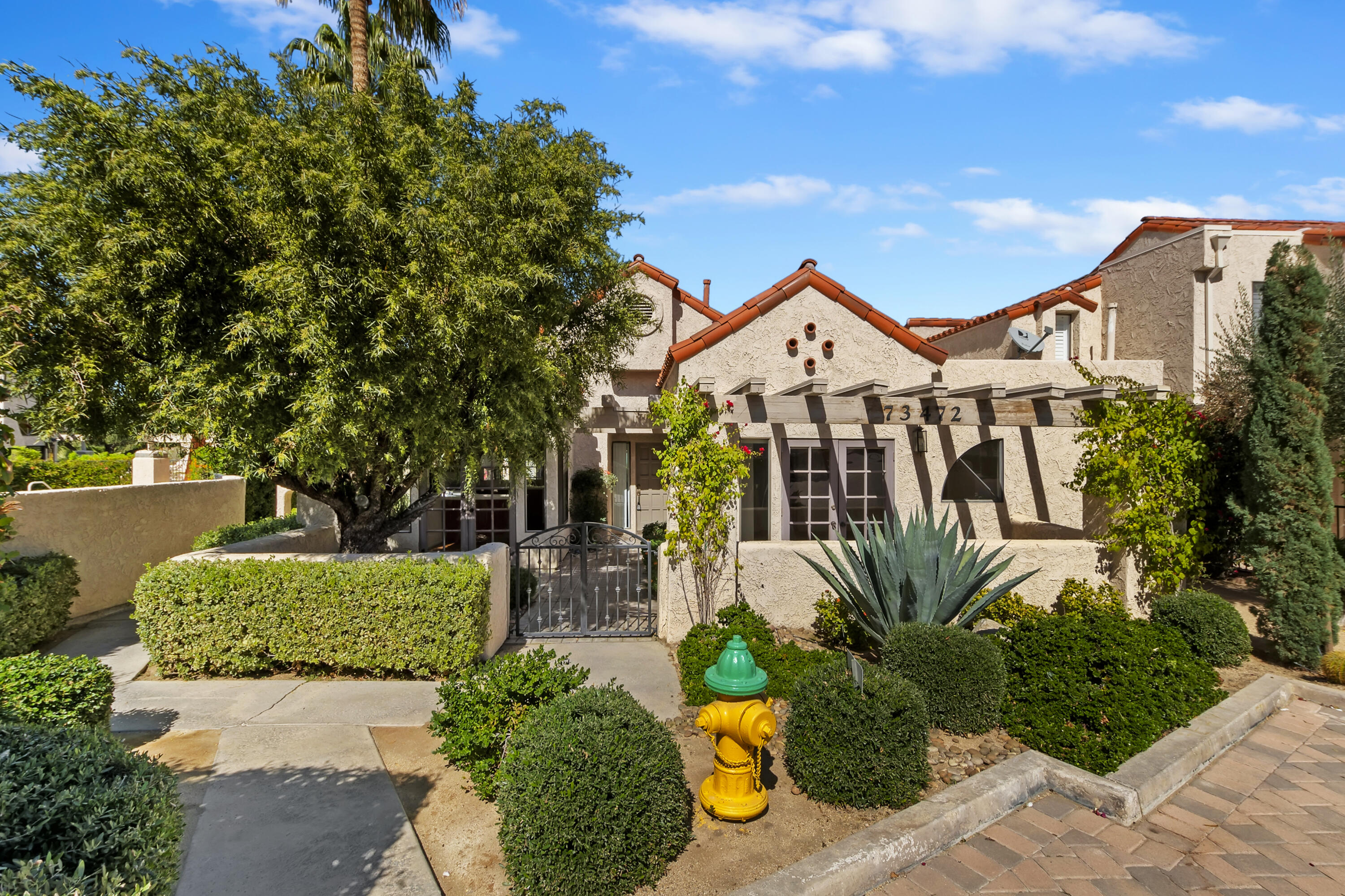 73472 Shadow Mountain Drive Palm Desert, CA 92260 - Photo 4 of 35 a front view of a house with a yard