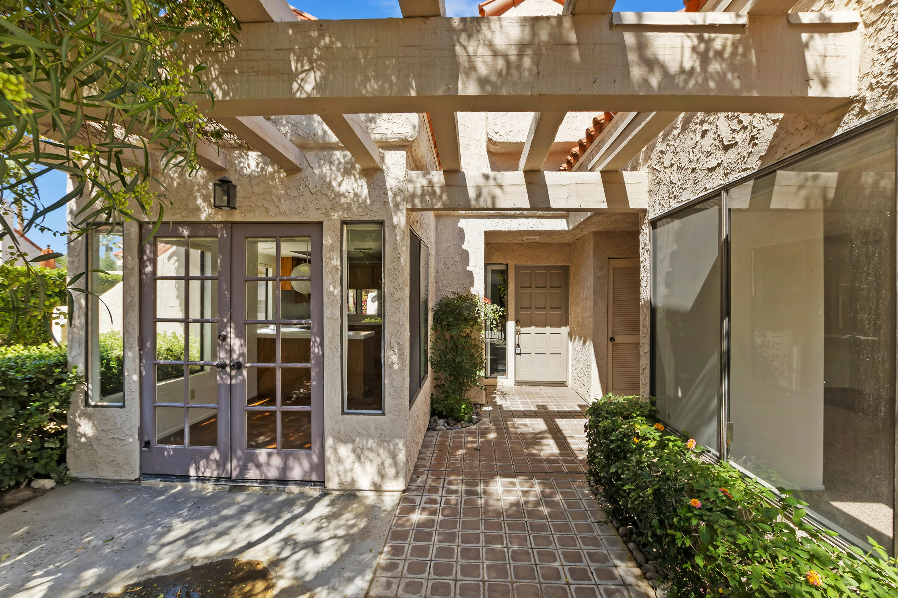 73472 Shadow Mountain Drive Palm Desert, CA 92260 - Photo 5 of 35 a view of a brick house with a large windows