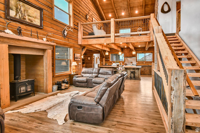 544 East 600 North, Unit 1 Joseph, UT 84739 - Photo 4 of 65 Spacious open-concept interior featuring wood-finish flooring, exposed wood beams, a wood-burning stove, a kitchen island, and an open loft area
