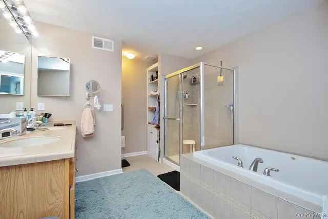 a bathroom with a tub a sink and a large mirror
