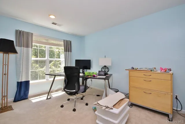 a view of a workspace with furniture and a window