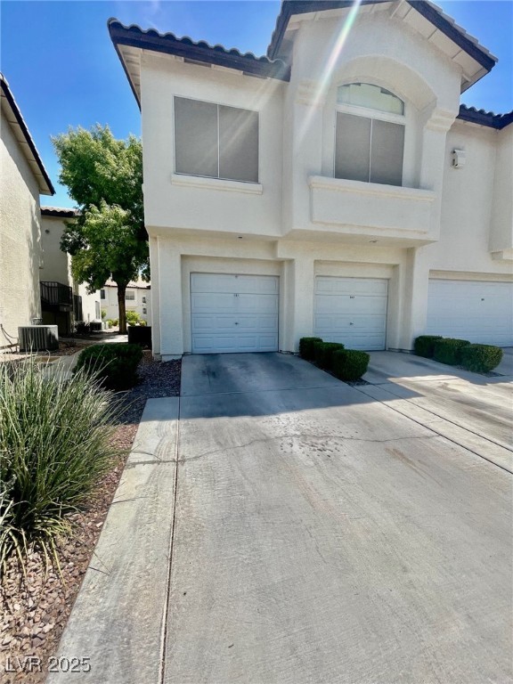 4810 Grey Wolf Lane, Unit 101 Las Vegas, NV 89149 - Photo 2 of 7 View of front of house featuring concrete driveway, an attached garage, and stucco siding