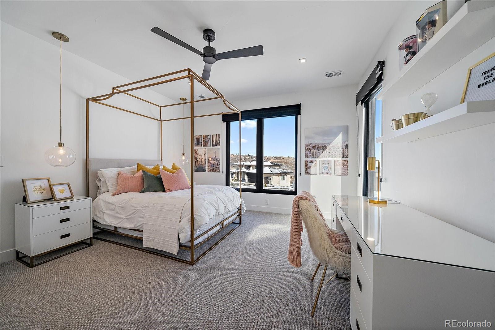 5263 Creation Rock Trail Morrison, CO 80465 - Photo 35 of 50 a spacious bedroom with a bed large window and a chandelier