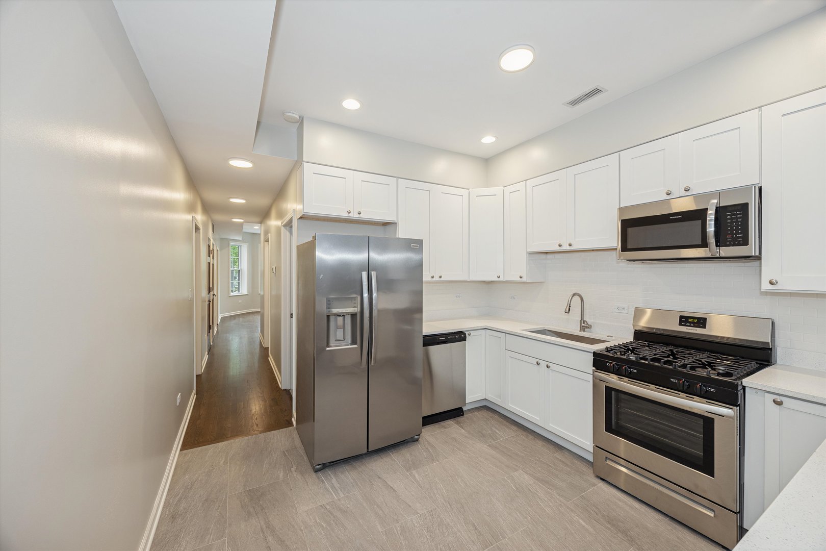 2008 West Addison Street, Unit 2 Chicago, IL 60618 - Photo 4 of 19 a kitchen with stainless steel appliances granite countertop a refrigerator a stove a sink and a microwave