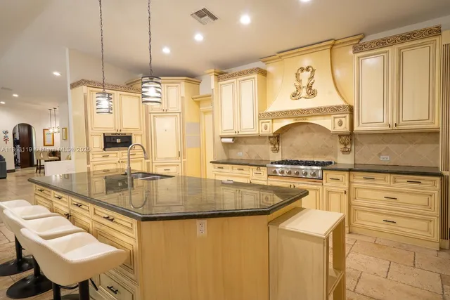 a kitchen with stainless steel appliances granite countertop a sink stove and cabinets
