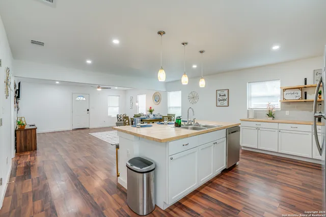 a kitchen with a sink and wooden floor