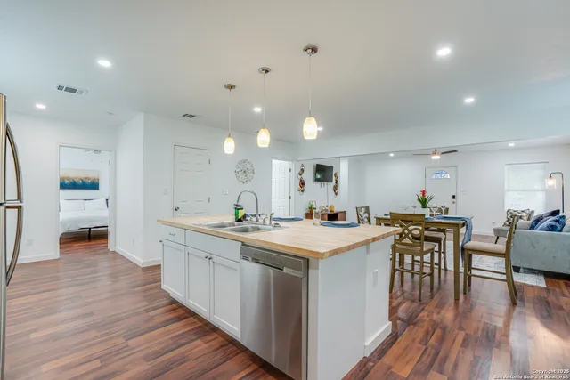 a kitchen with a sink cabinets and wooden floor