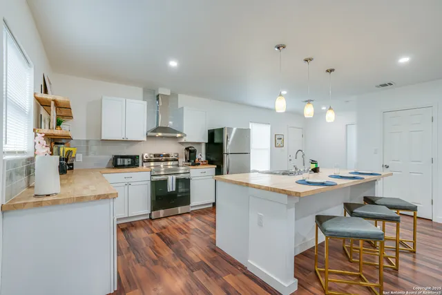 a kitchen with kitchen island a sink stove and refrigerator