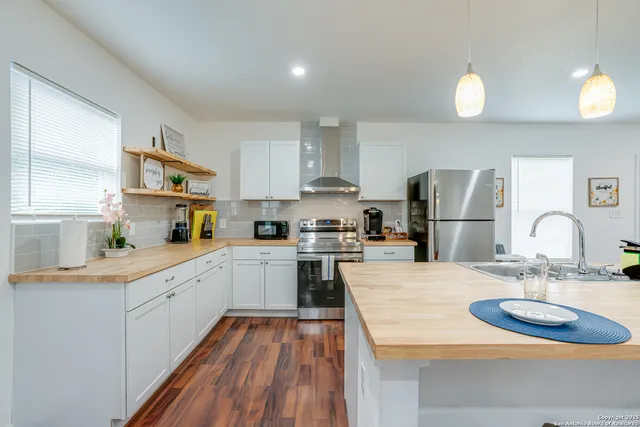 a view of a kitchen area with furniture and wooden floor