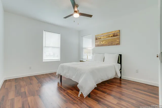 a bed room with a bed and a ceiling fan