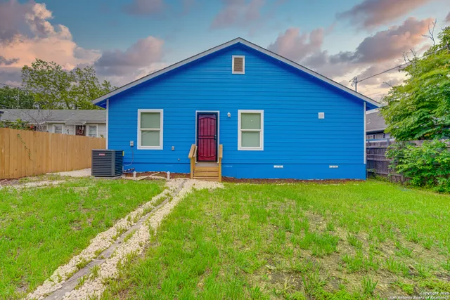 a view of backyard of house with green space