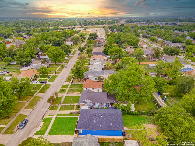 an aerial view of residential houses with outdoor space and street view