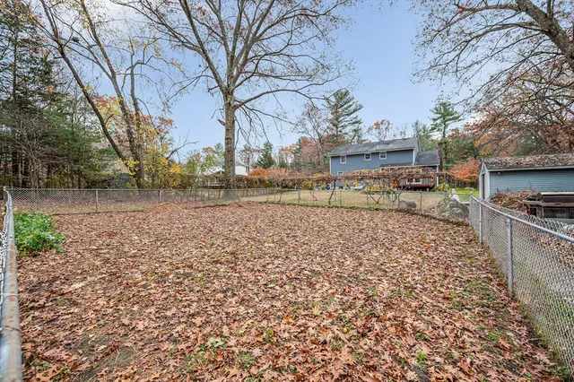 a view of a yard with wooden fence