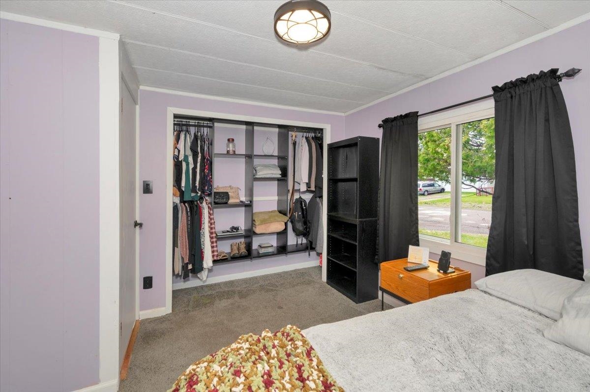 1632 9th Avenue Two Harbors, MN 55616 - Photo 14 of 21 Bedroom with baseboards, carpet, crown molding, and a closet