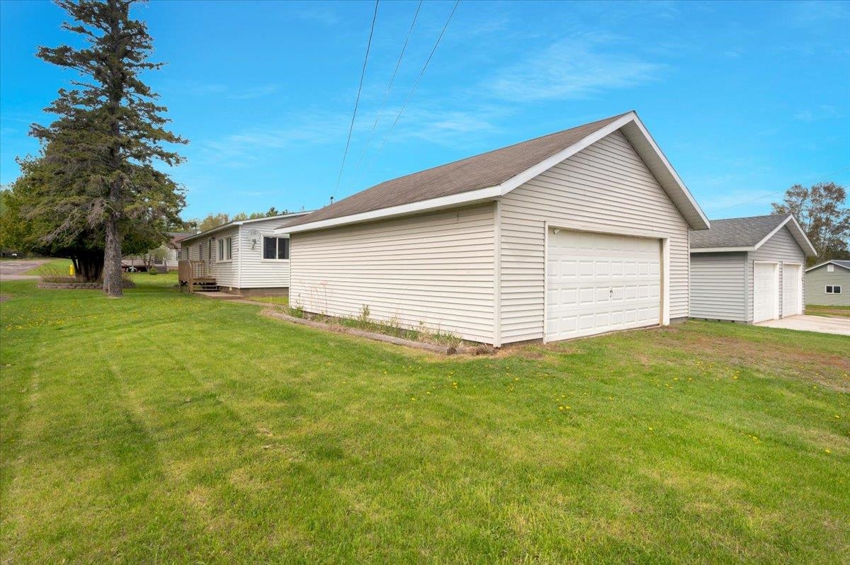 1632 9th Avenue Two Harbors, MN 55616 - Photo 2 of 21 View of side of home with a garage, an outbuilding, and a yard