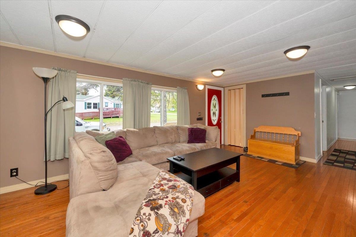 1632 9th Avenue Two Harbors, MN 55616 - Photo 5 of 21 Living room featuring light wood-style flooring, baseboards, and ornamental molding