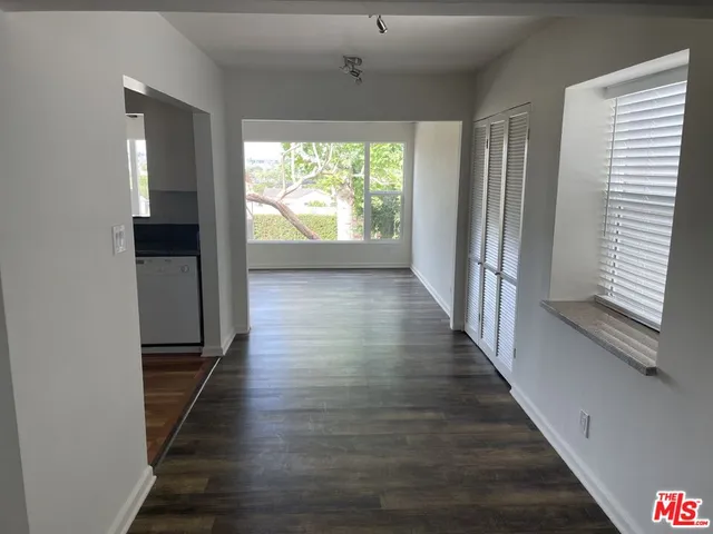 a view of a hallway with wooden floor and stairs