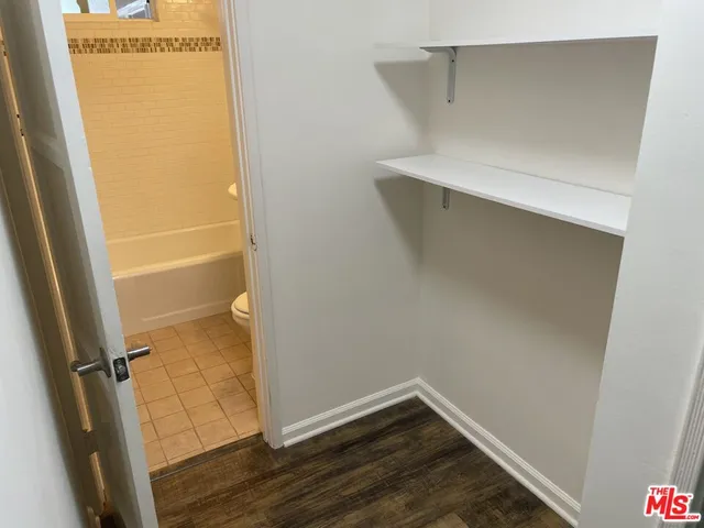 a view of walk in closet with wooden floor