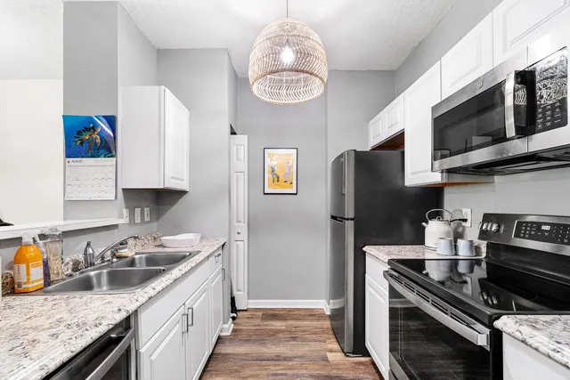 a kitchen with stainless steel appliances granite countertop a sink dishwasher stove microwave and refrigerator