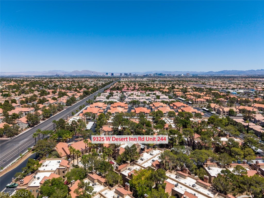 9325 West Desert Inn Road, Unit 244 Las Vegas, NV 89117 - Photo 51 of 55 An aerial panorama reveals a vast urban landscape stretching towards distant mountains and the city skyline.