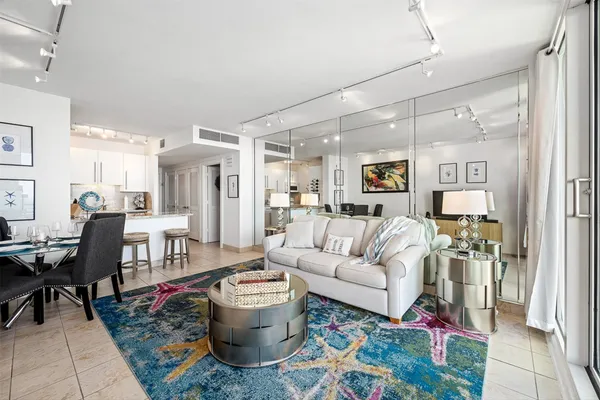 a living room with furniture and a dining table with wooden floor