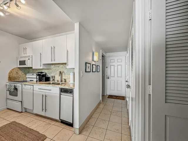 a kitchen with white cabinets and white appliances