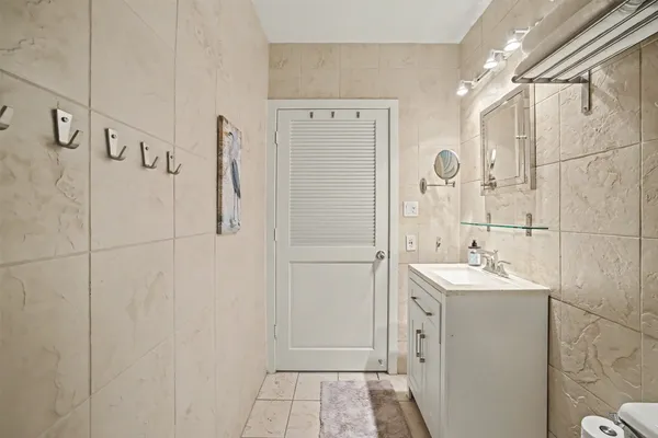 a bathroom with a sink a toilet a mirror and shower