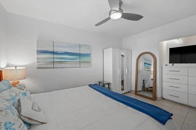 a bedroom with a bed and a flat tv screen on the dresser