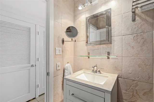 a bathroom with a sink and mirror with toilet