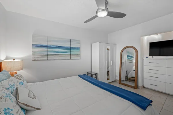a bedroom with a bed and a flat tv screen on the dresser