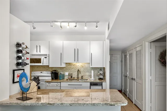 a view of kitchen with refrigerator stove and window