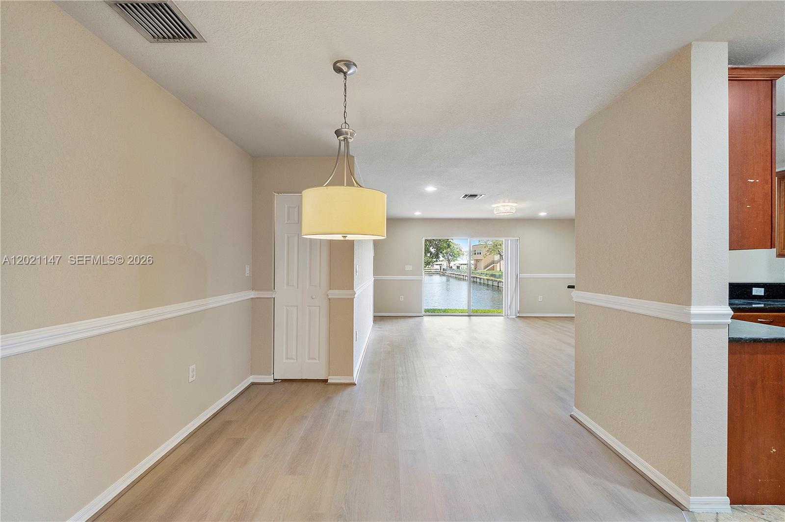 5930 Abbey Road Tamarac, FL 33321 - Photo 4 of 26 a view of a room with wooden floor water heater and a kitchen space