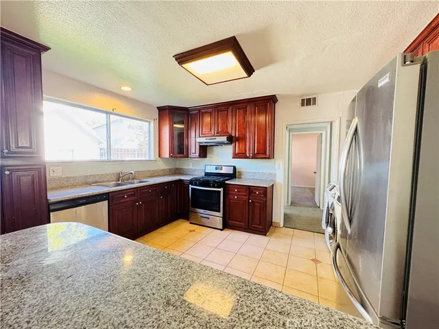 a kitchen with stainless steel appliances granite countertop a refrigerator stove a sink and dishwasher